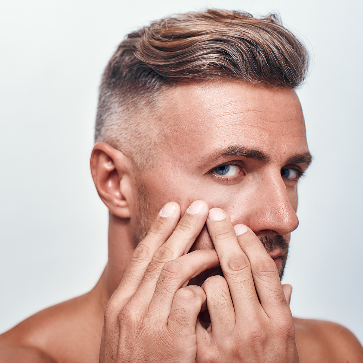 Middle-aged man examining eye bags