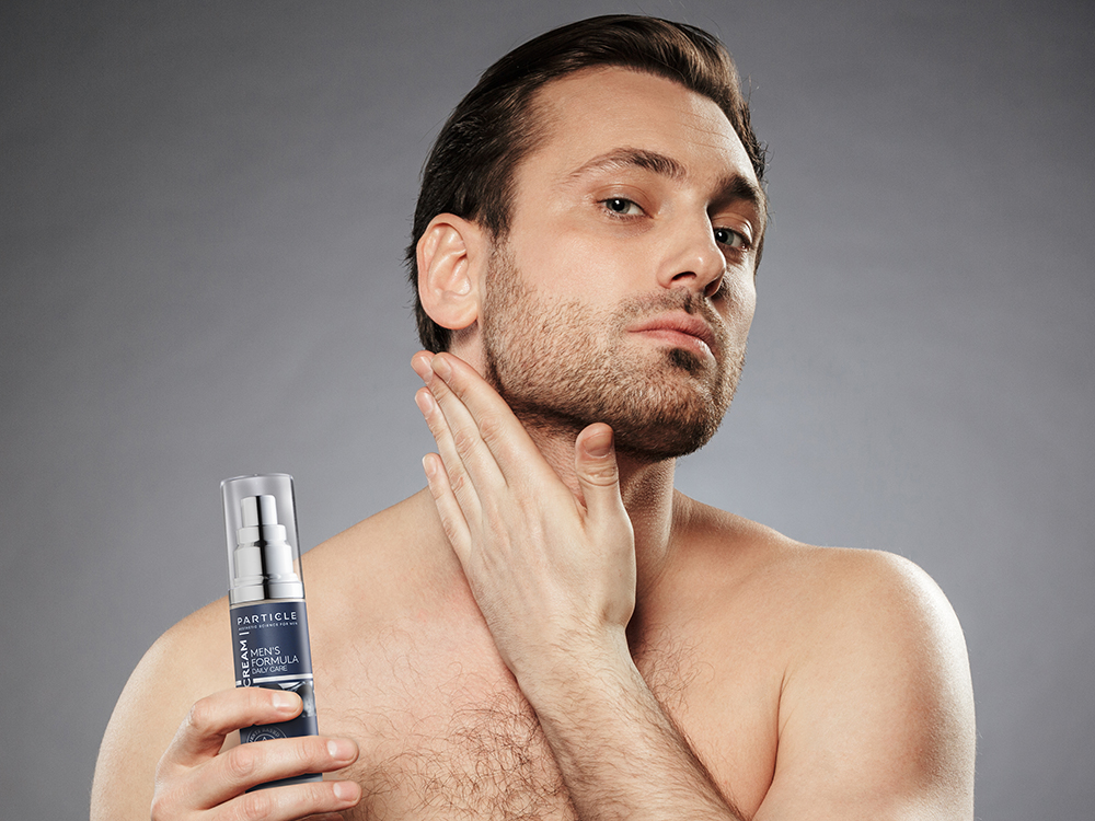 Man holding Particle Face Cream bottle