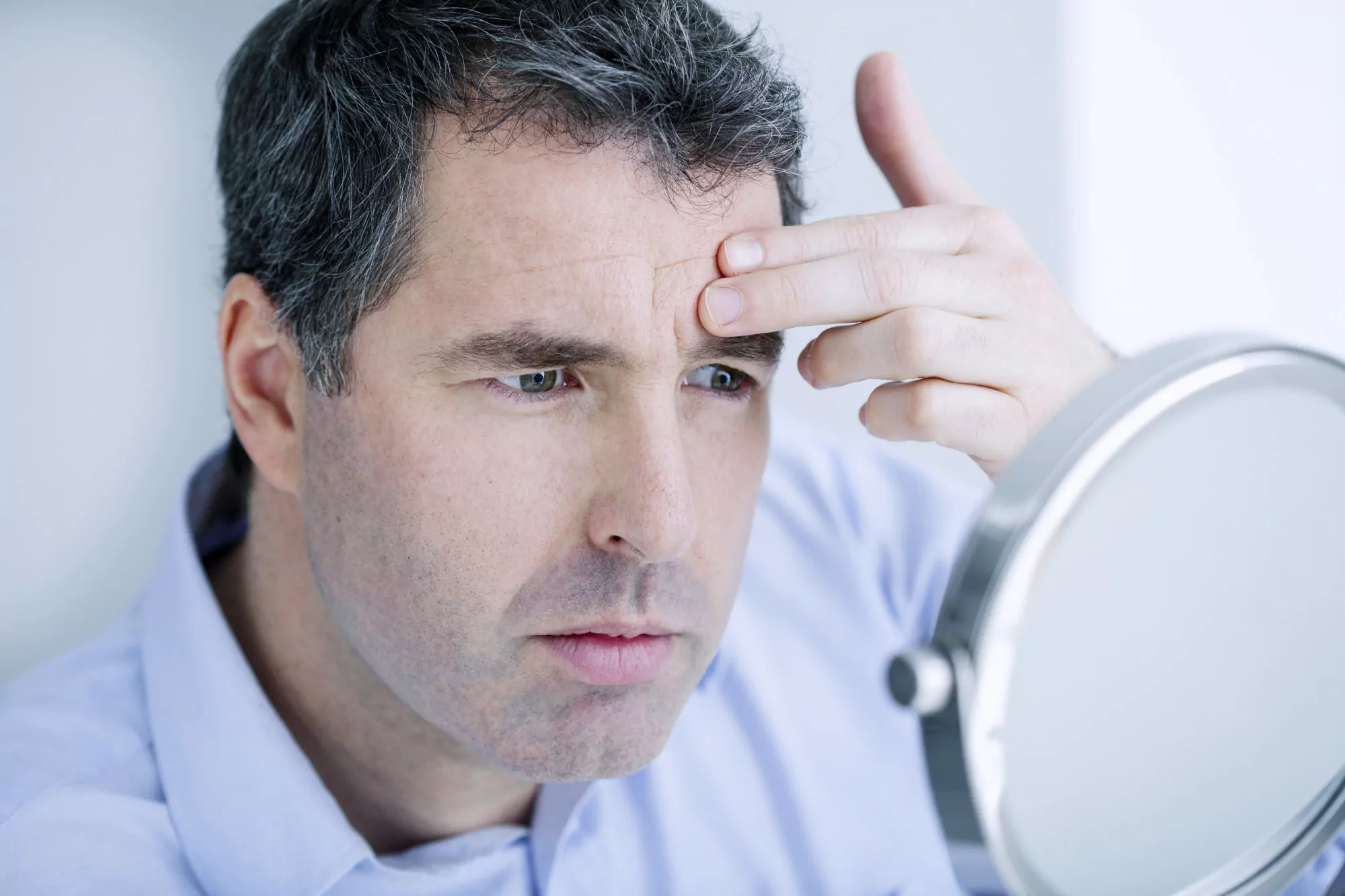 Man Looking At Himself In The Mirror